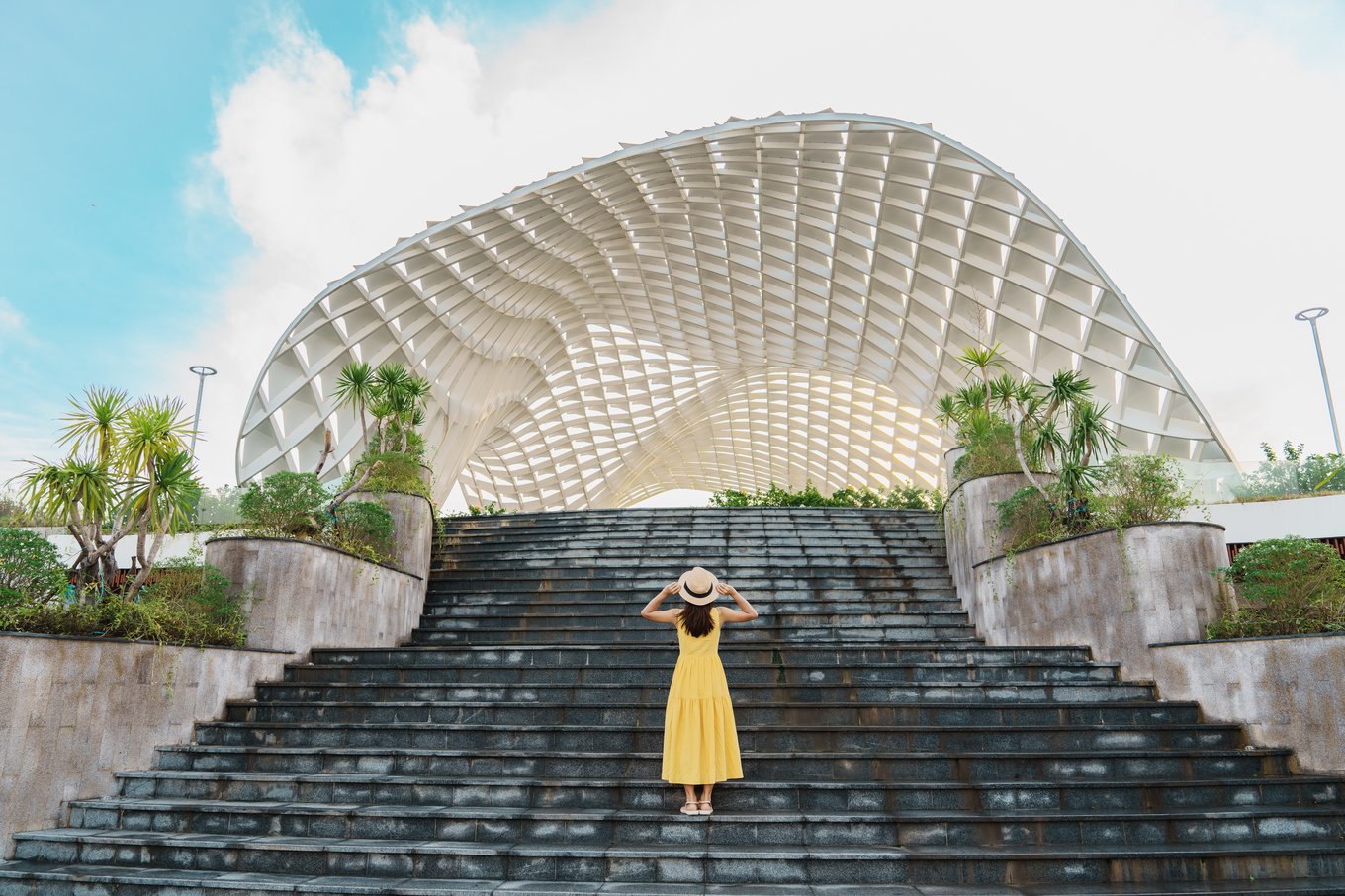 Woman in yellow dress standing at an architectural landmark in Vietnam