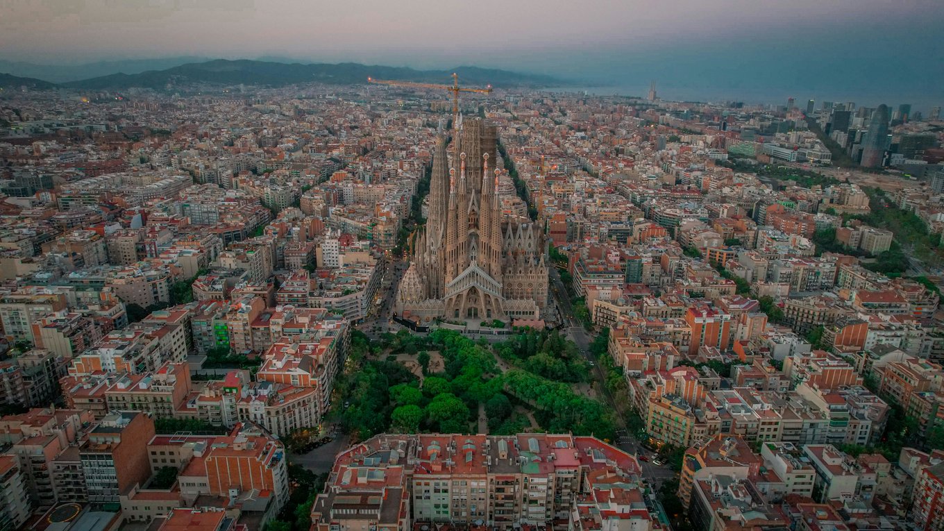Barcelona skyline aerial featuring Sagrada Familia and surrounding neighborhoods