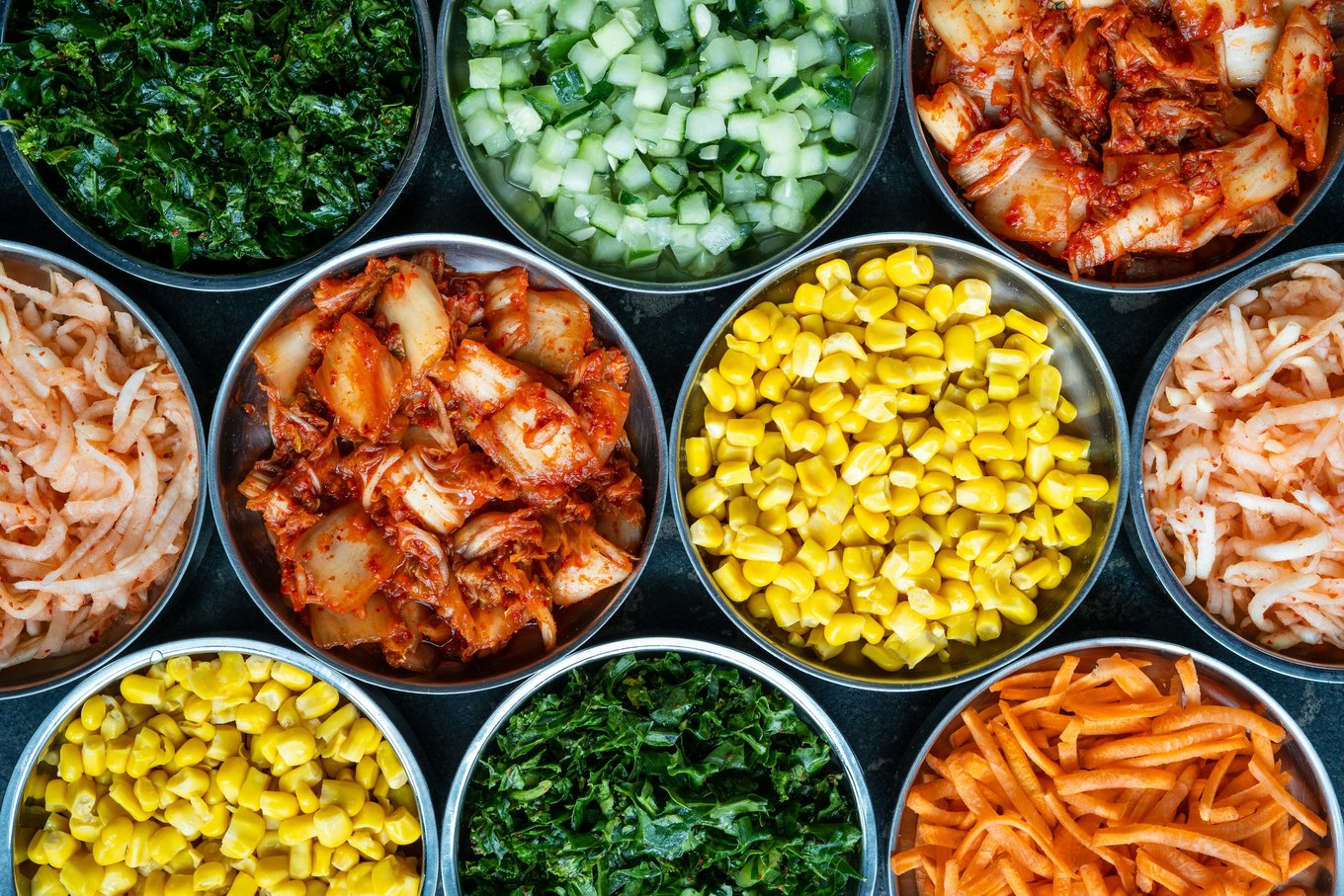 Assorted kimchi and vegetable side dishes in bowls | Photo Credit: Shaun Tilburg on Unsplash