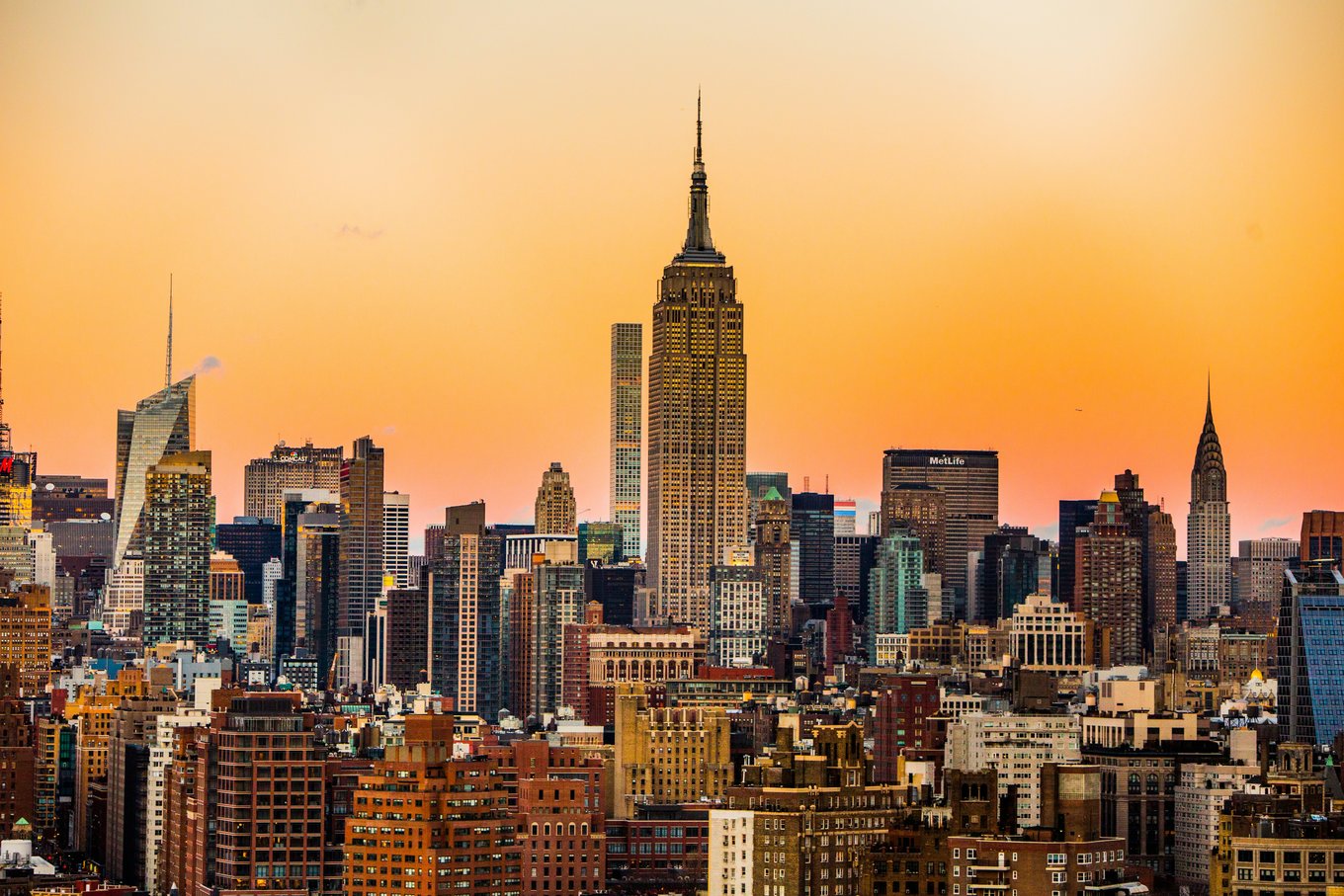 Skyscrapers and tall buildings against a bright orange sunset