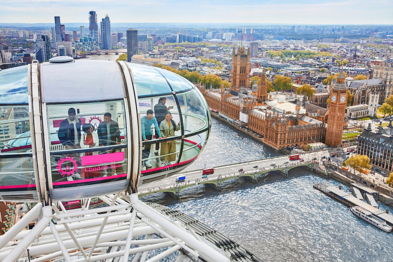 Tourists riding the London Eye capsule overlooking Big Ben and the River Thames in London