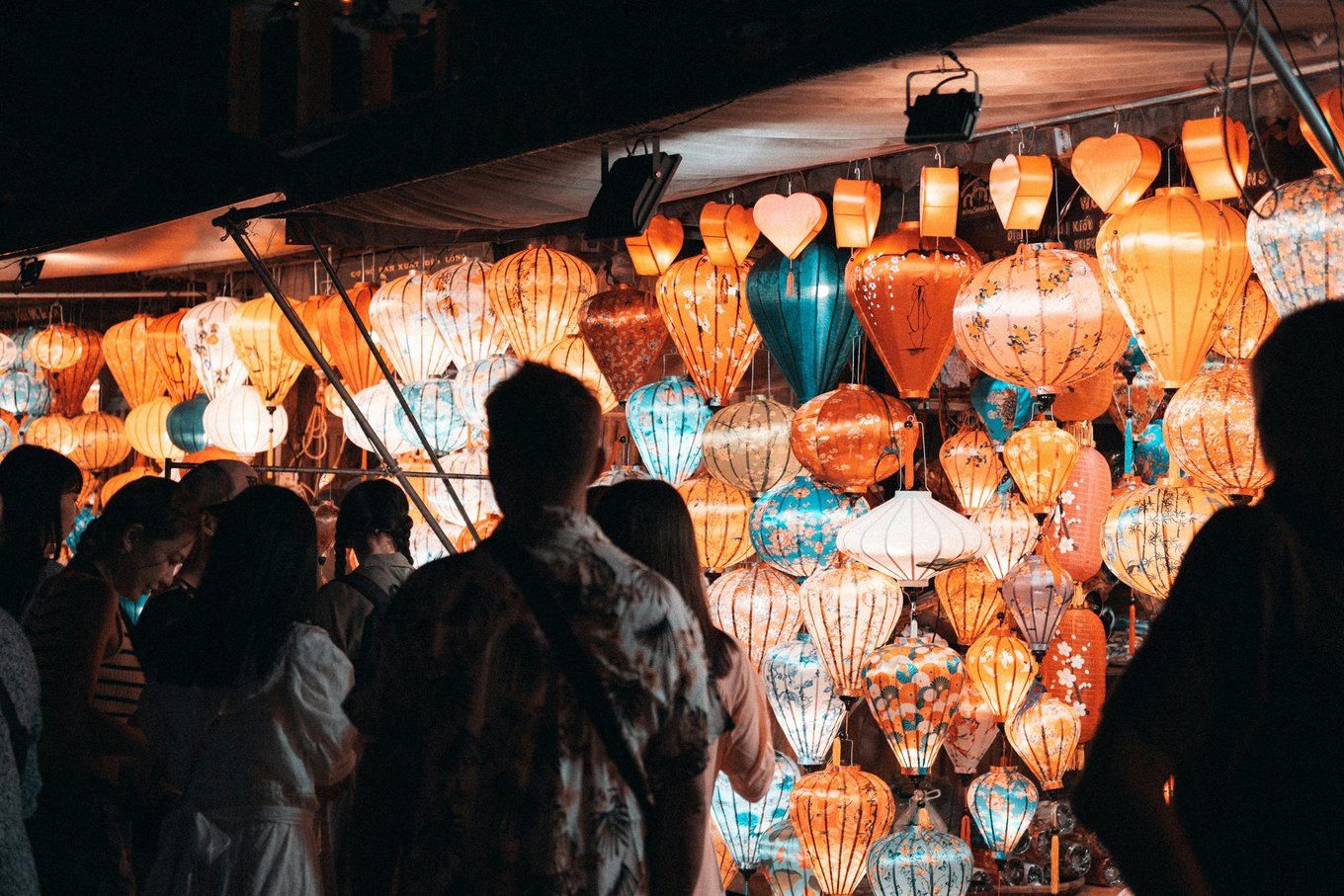 Shoppers browsing colorful lanterns at Hoi An night market | Photo Credit: Michael Lock on Unsplash