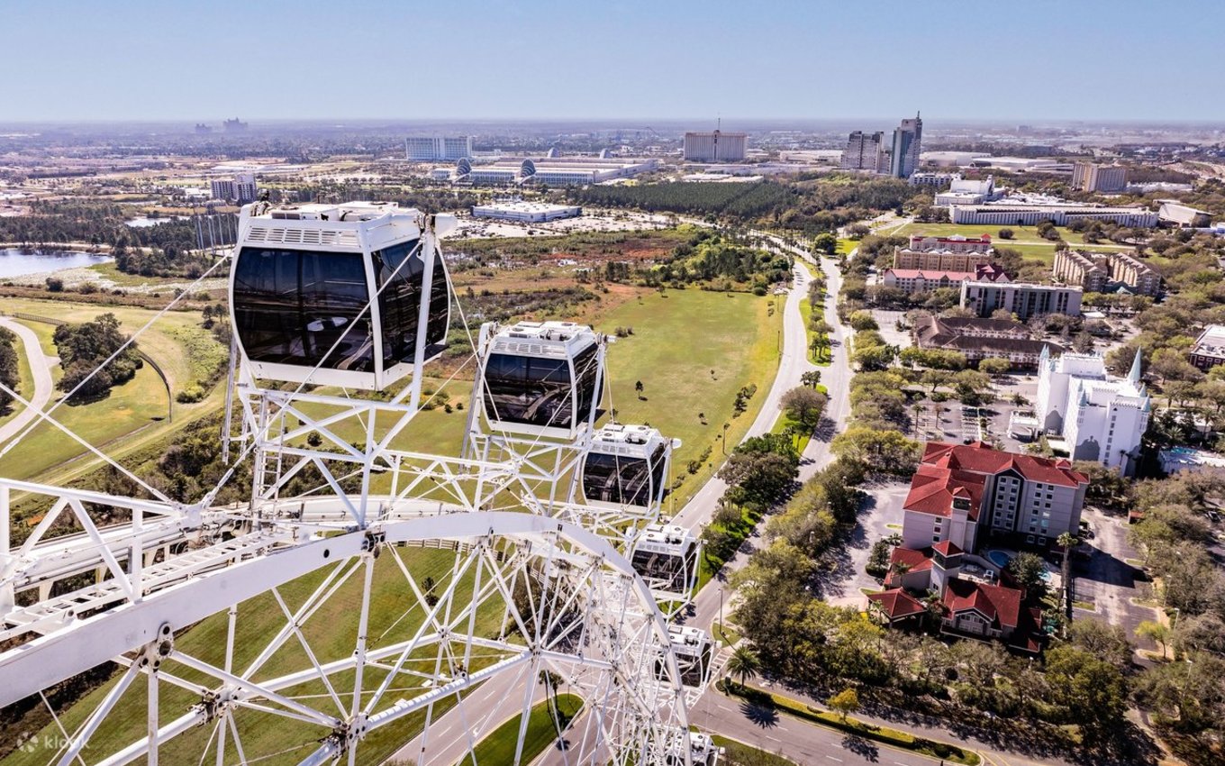 Close-up of The ICON observation wheel cabins with a wide view of Orlando’s skyline and roads below