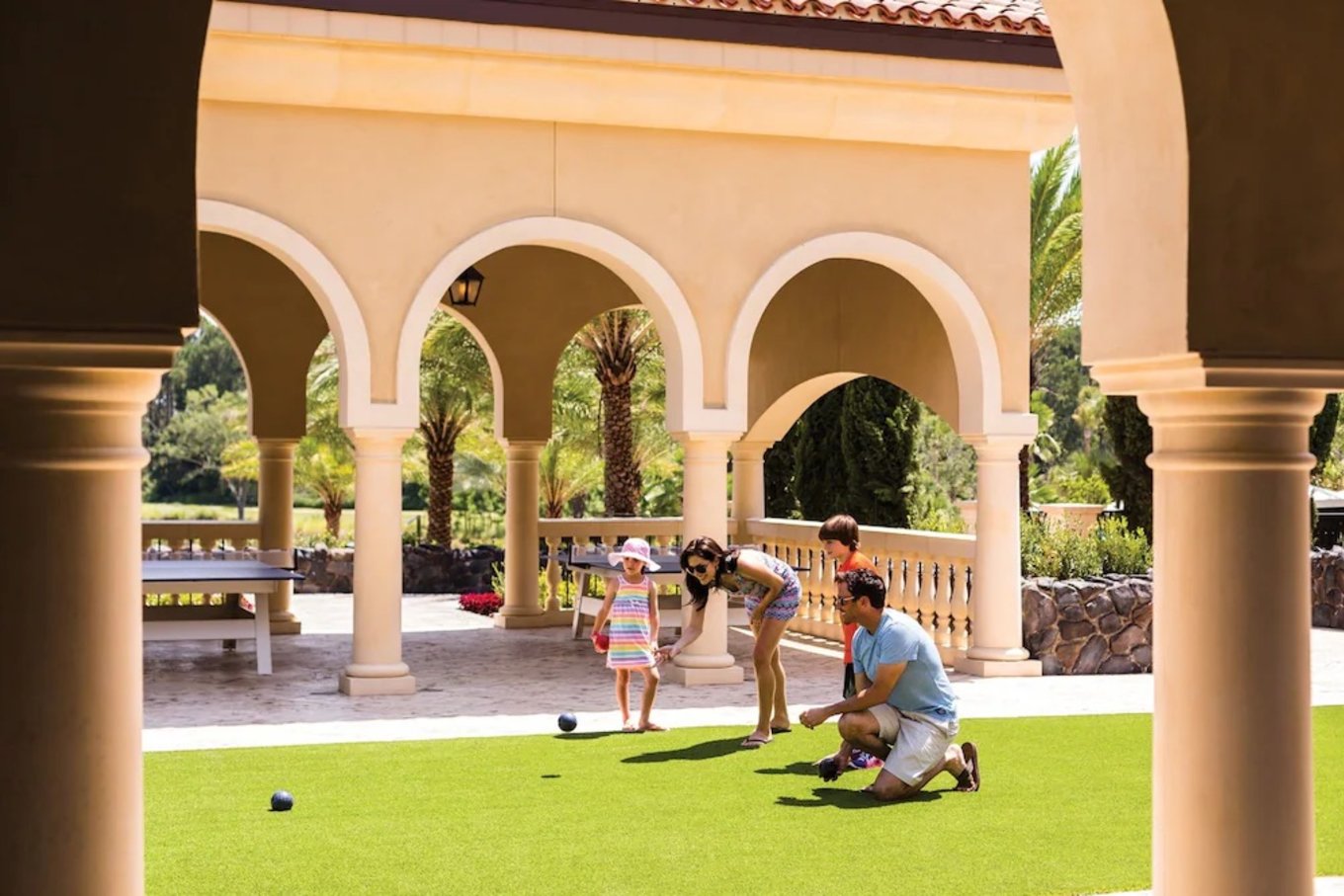 Parents and kids playing lawn games at a family hotel in Orlando courtyard