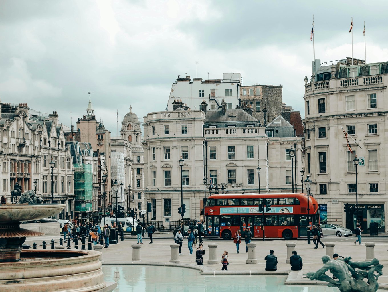 Busy London street featuring a red double-decker bus and historic buildings