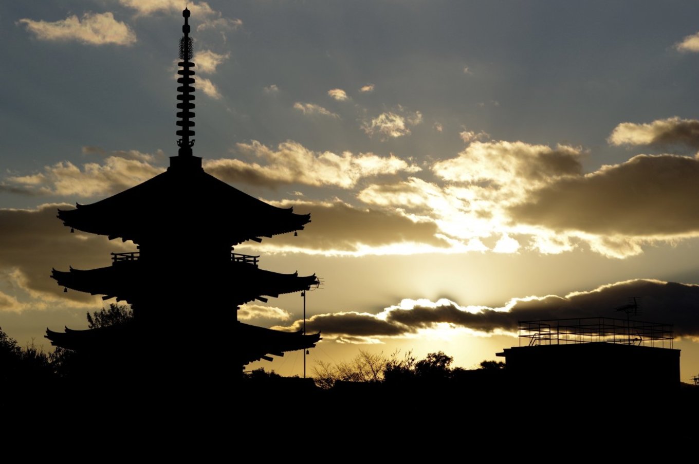 A sunrise foregrounded by a silhouette of a pagoda