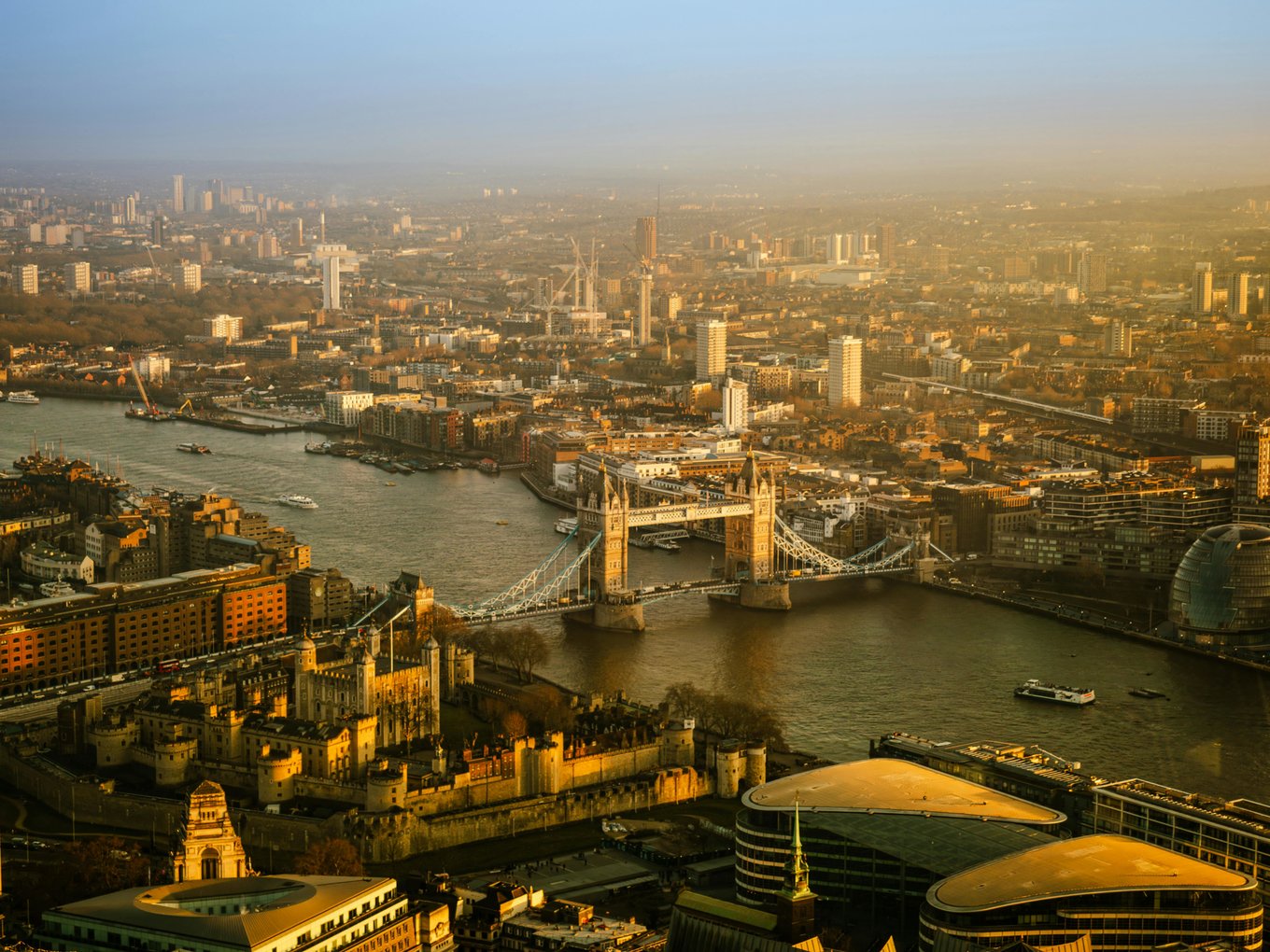 Aerial view of London, featuring Tower Bridge and city skyline along the River Thames