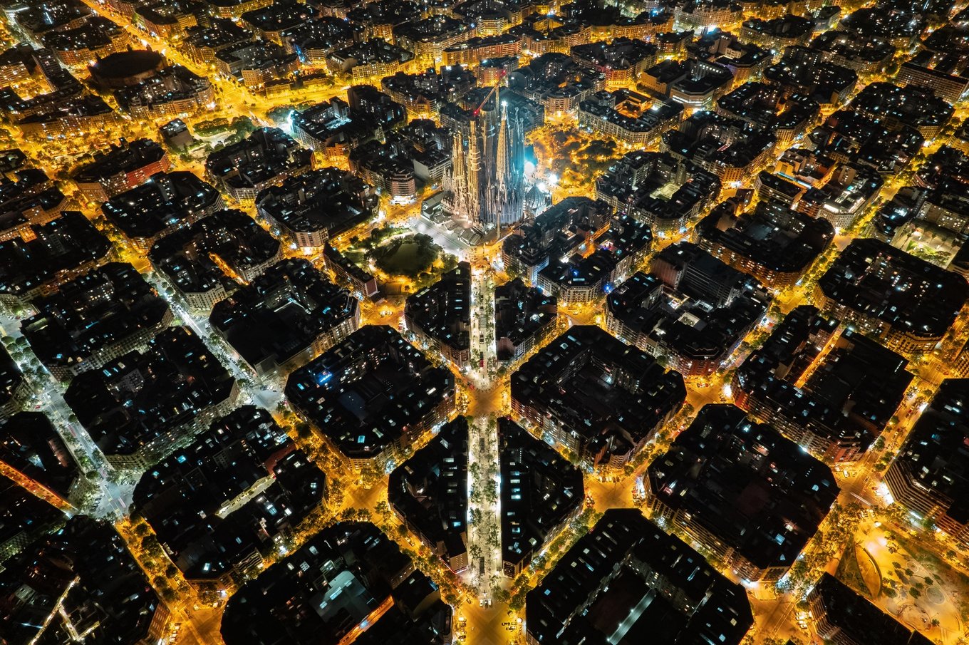 Aerial view of Sagrada Família glowing at night in Barcelona city lights