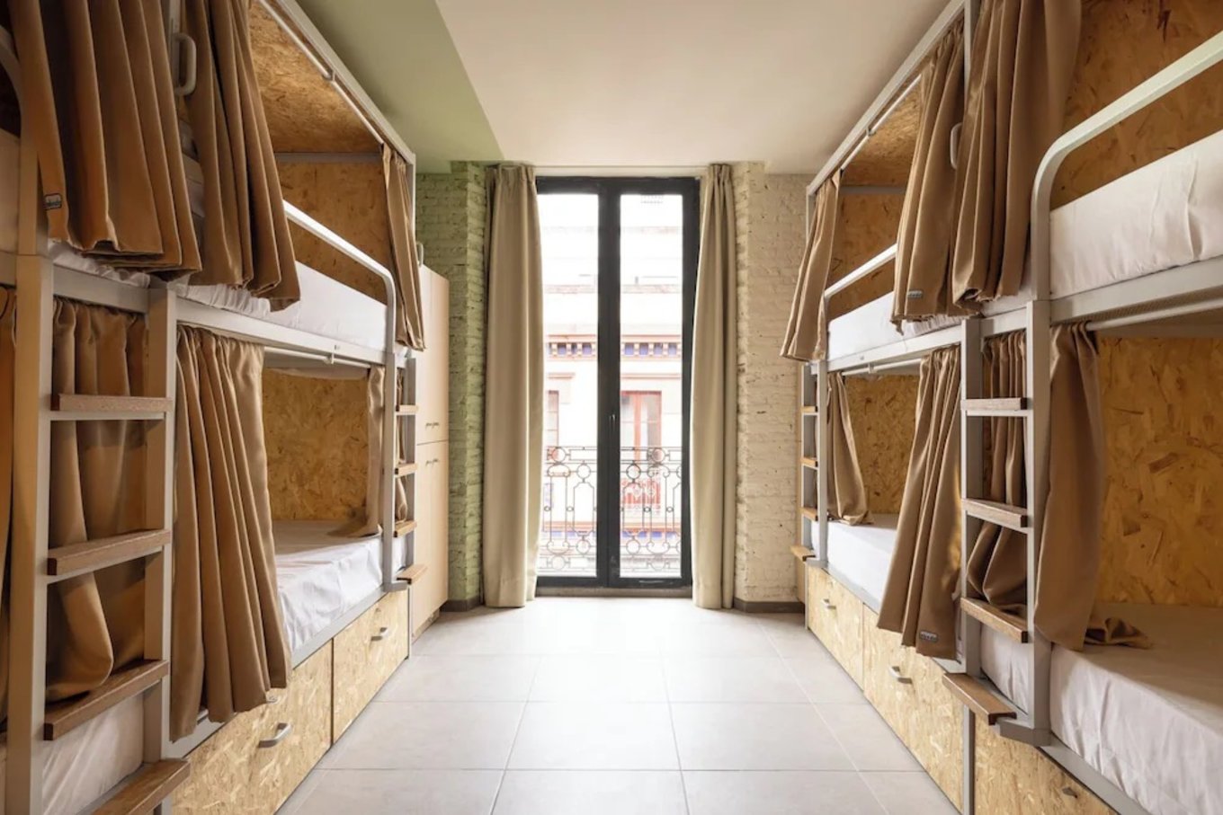 Modern bunk beds with privacy curtains at The Loft House Sevilla hostel in Seville