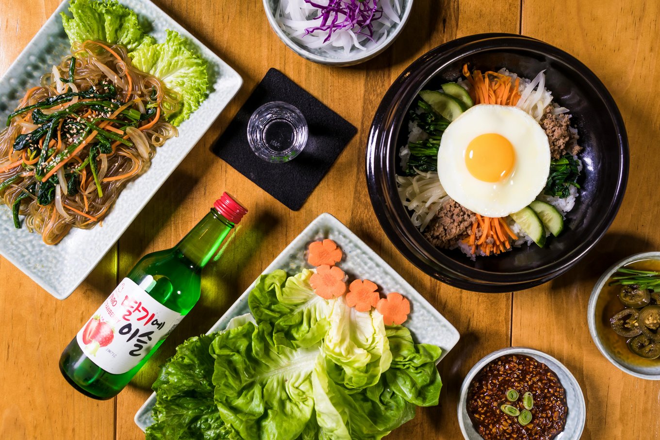Korean food spread with bibimbap, japchae, and soju