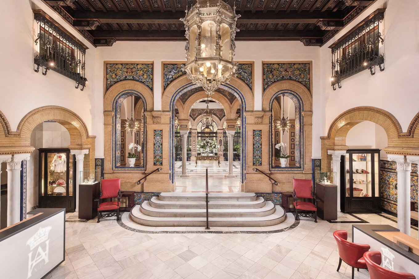 Grand hotel lobby of Hotel Alfonso XIII with Moorish arches, intricate tiles, and an ornate chandelier