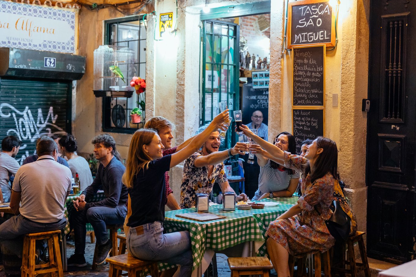 Friends sharing and toasting drinks in a bar in Seville | Photo Credit: Wikimedia Commons