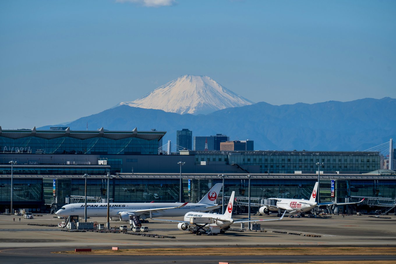 Airplanes on an airport runway in a Japan terminal with a view of Mount Fuji