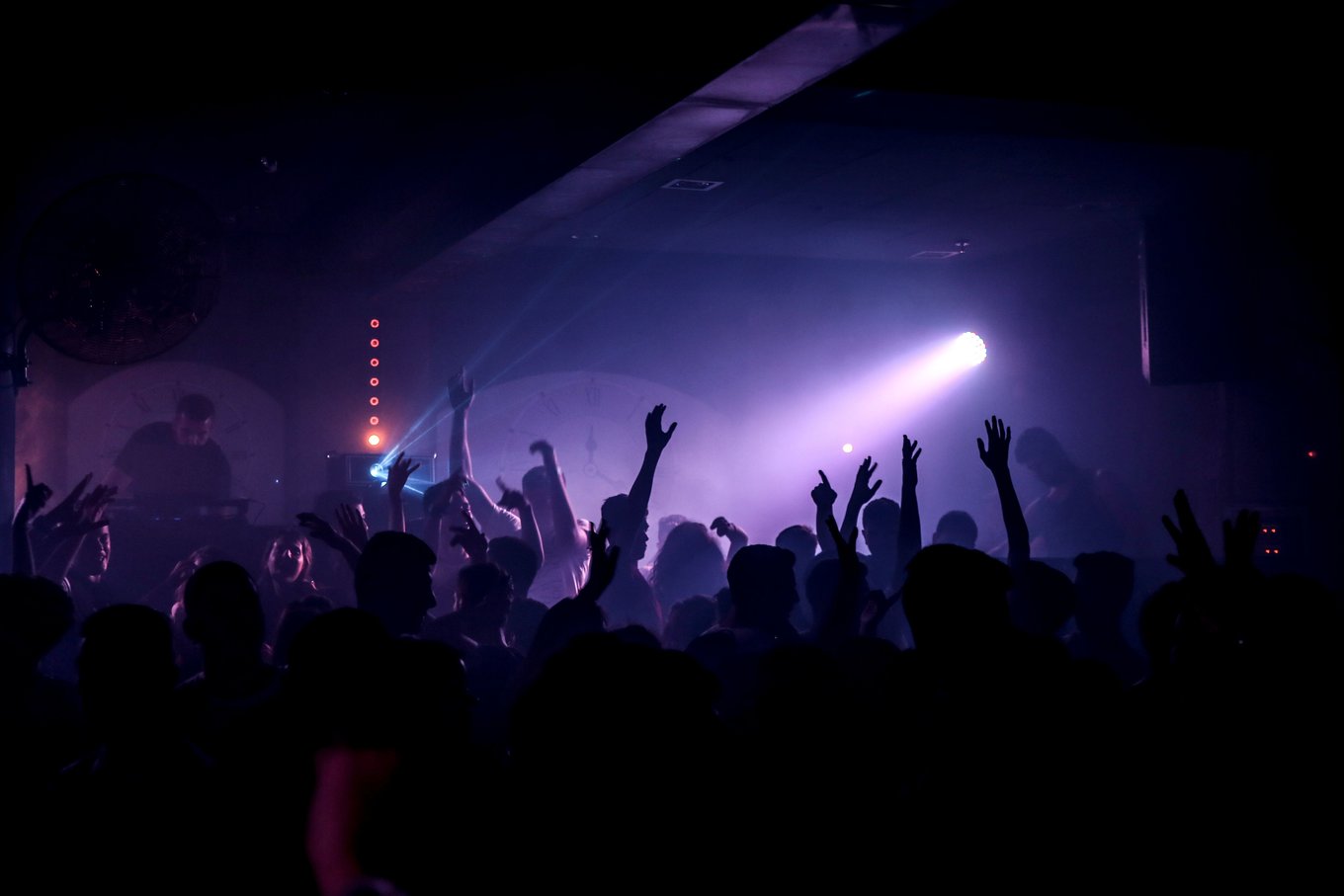 Energetic crowd dancing in a lively nightclub under spotlights | Photo Credit: Maor Attias on Pexels
