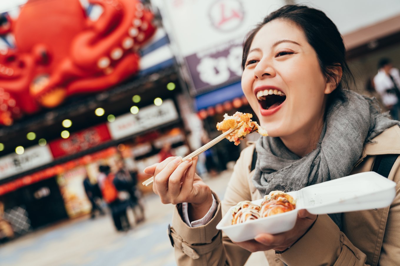 woman holding a box of local japanese street food