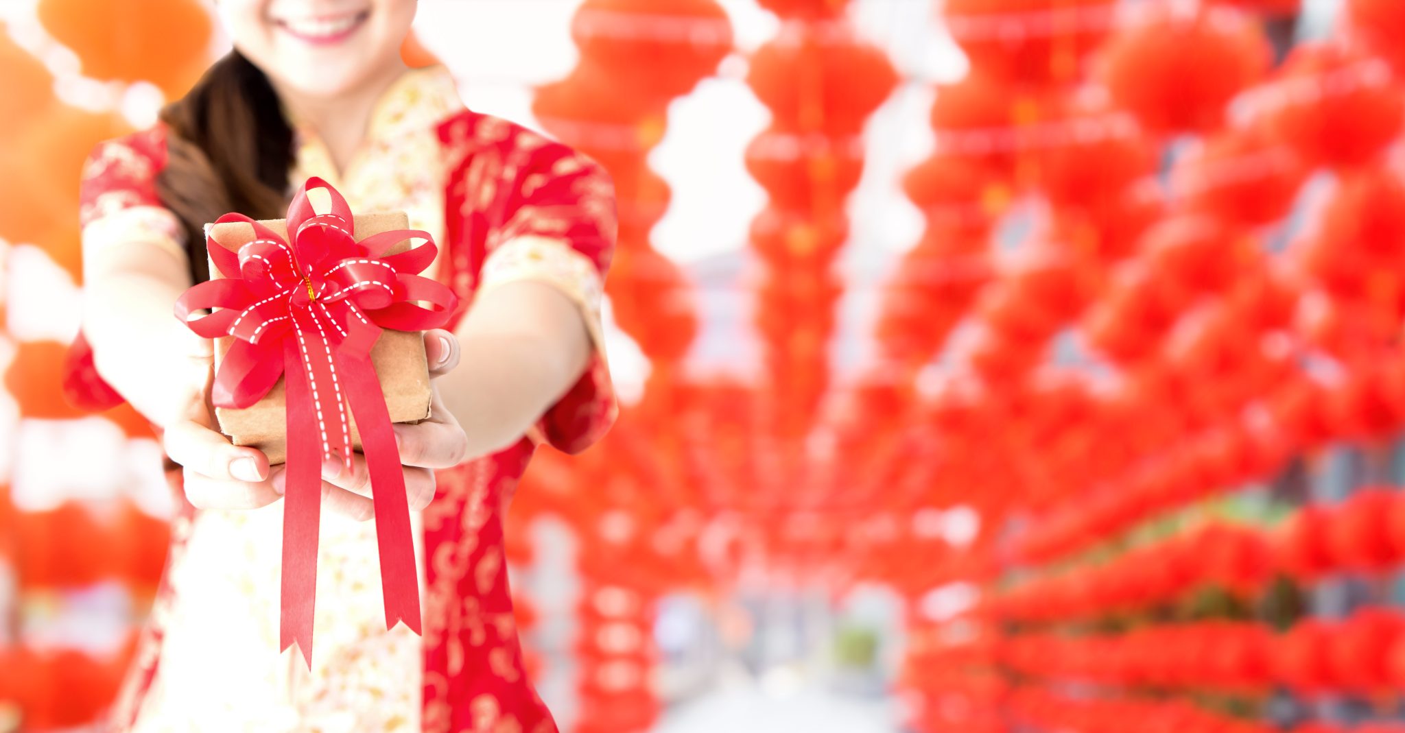 happy-chinese-new-year-asian-woman-holding-gift-box-copy-space-red-lanterns-blur-background-2048x1069