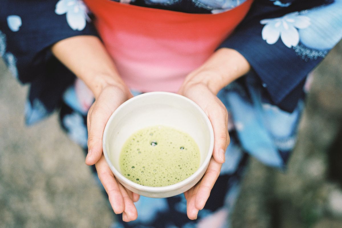 woman holds a cup of matcha