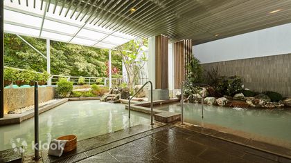 A covered outdoor hot spring pool surrounded by greenery at The Gaia Hotel in Beitou