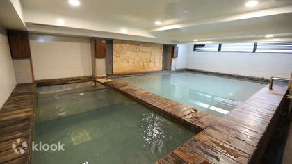 A long indoor thermal pool with wooden decking, a short walk from Xinbeitou station