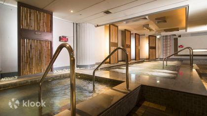 The indoor bathing hall at Nan Fung — stone pools under warm wooden ceilings