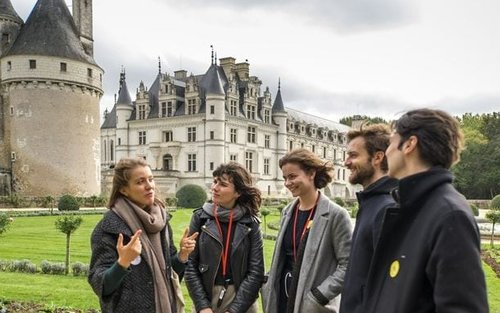 A group of people talking in front of a castle