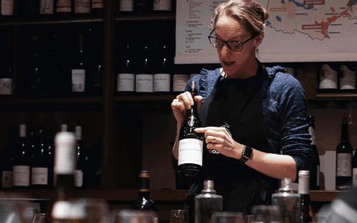 A sommelier explaining a wine bottle's label
