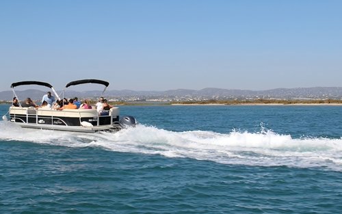 Tourists enjoy a scenic boat ride through peaceful waters, framed by distant hills