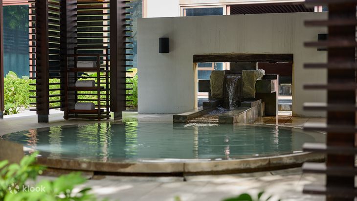 The green thermal pool behind wooden louvred screens at Villa 32
