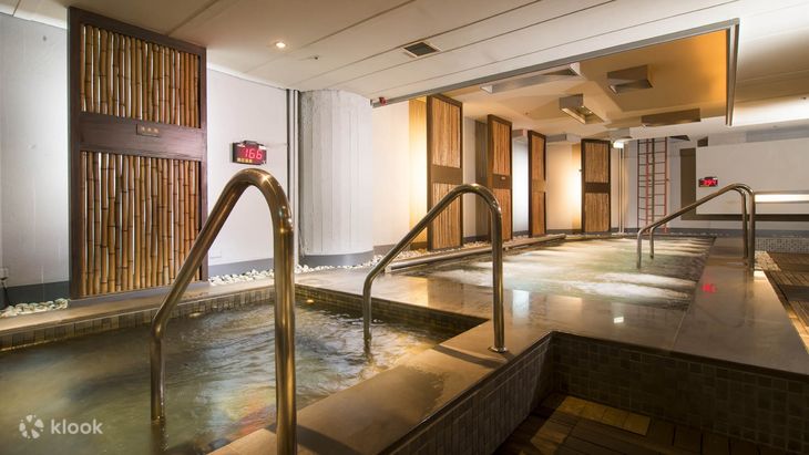 The indoor bathing hall at Nan Fung, stone pools under a warm wooden ceiling
