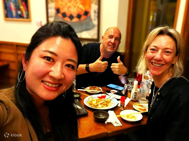 Small group eating together on a street food tour in Osaka