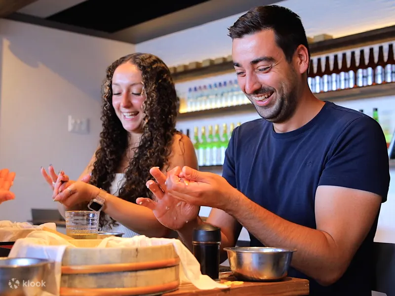 Visitors shaping nigiri sushi by hand at a sushi making class in Osaka