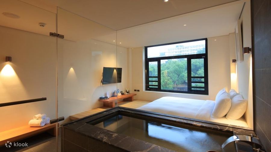A Beitou hotel room with its own sunken thermal tub beside the window