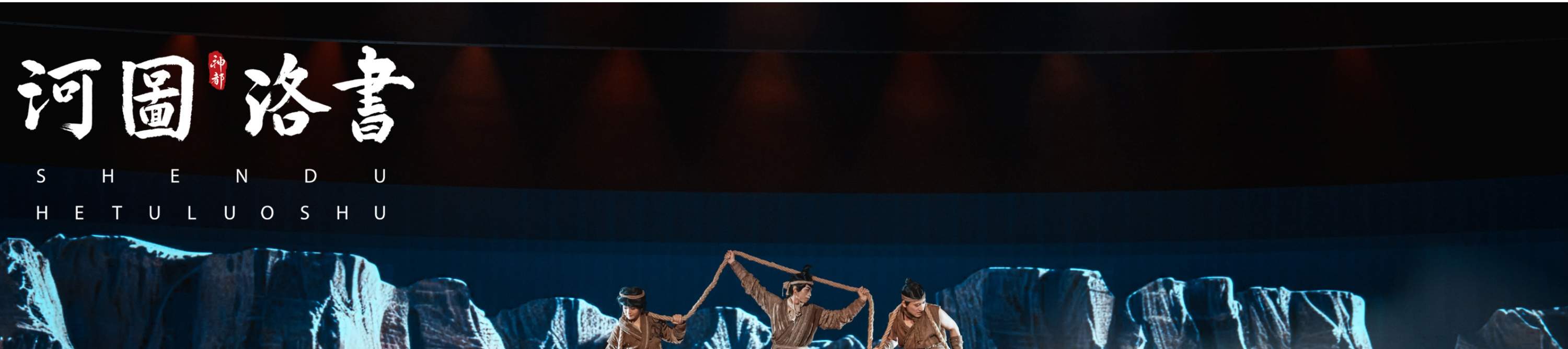 On a multi-layered stage, unified costumes, coordinated with ropes and props, and a realistic mountain rock background create a scene where their movements are orderly and full of power, as if they are performing a collective labor of an ancient tribe.