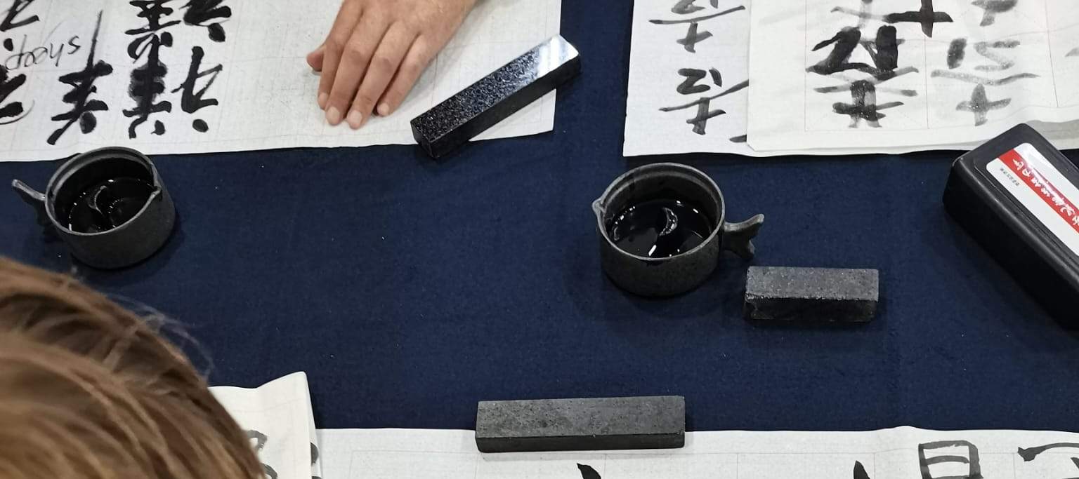 Mann schreibt chinesisches Schriftzeichen