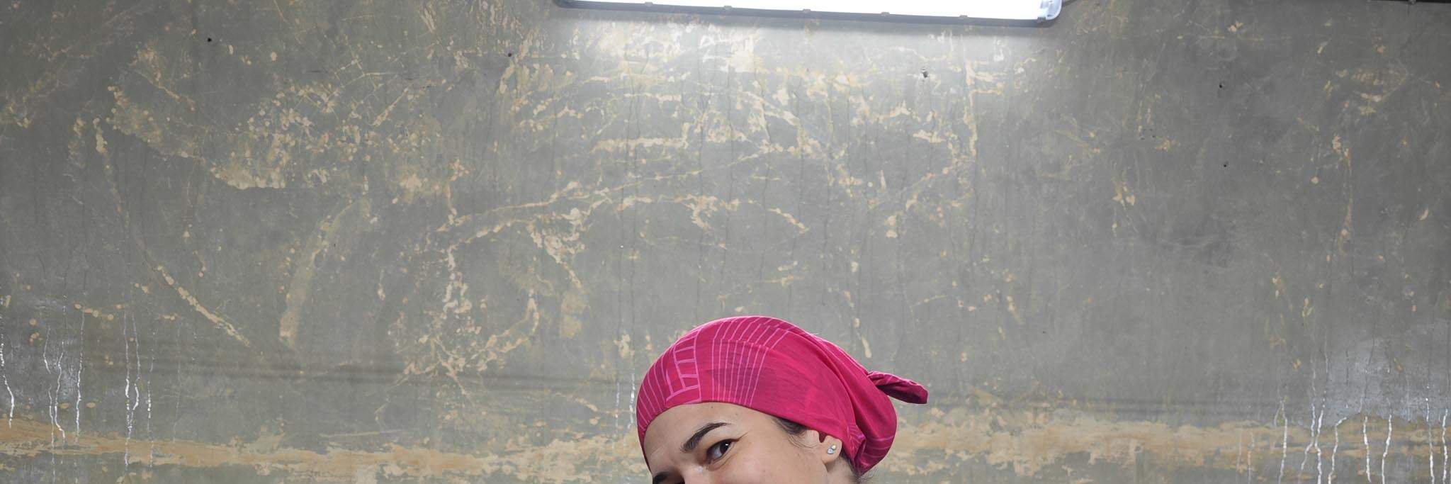 Silvia đang cầm một thùng IFCO màu đen đựng đầy nấm ăn tươi.