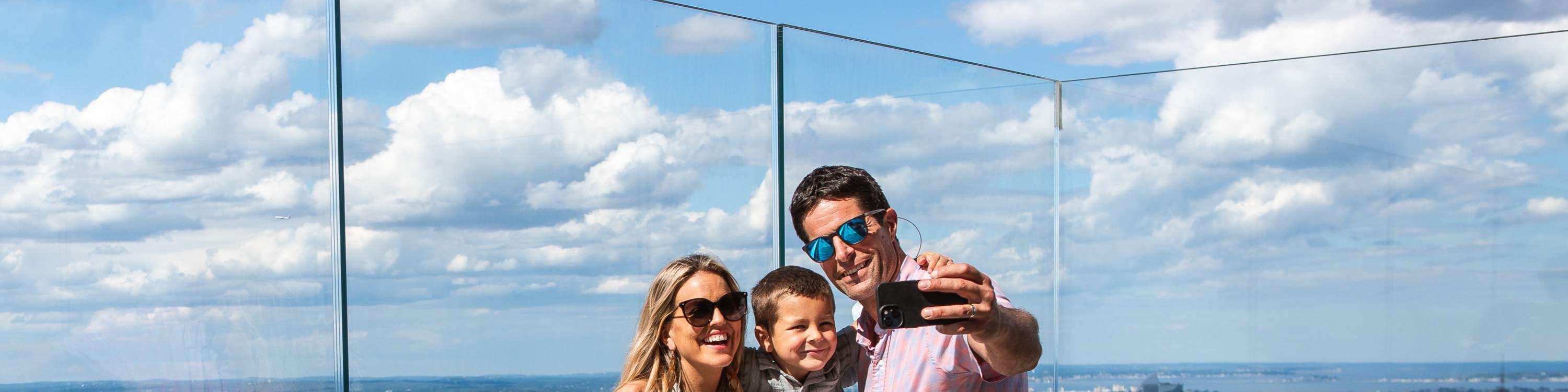 Machen Sie ein Familien-Selfie mit atemberaubendem Blick auf die Skyline von Boston von der Dachterrasse aus