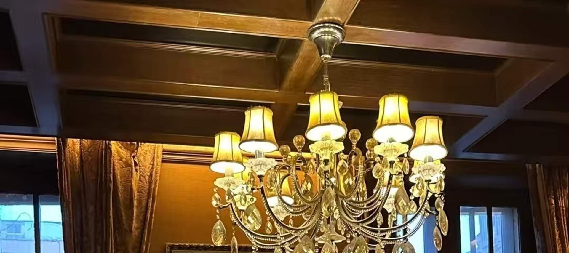 The living room is decorated with European-style genuine leather sofas, redwood coffee tables, and floor lamps from the period of the Republic of China. Western-style oil paintings hang on the walls, and a crystal chandelier hangs from the ceiling, reveal