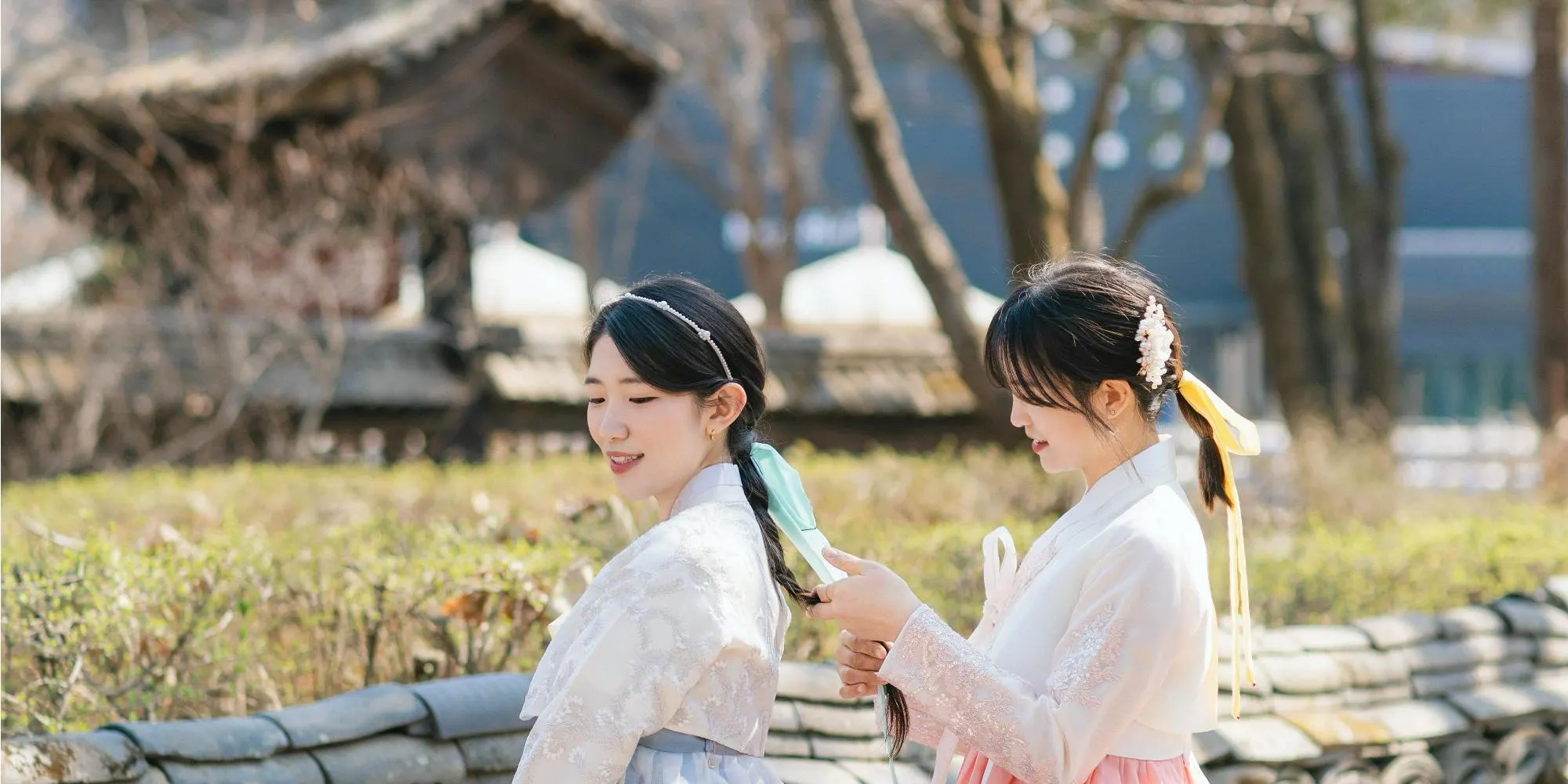 韩服在飘落的花瓣下随风飘扬，景色令人叹为观止。