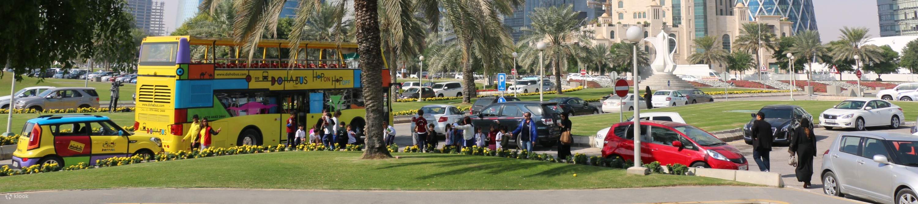 カタールのドーハにある象徴的なコーニッシュを通過する2階建てバス