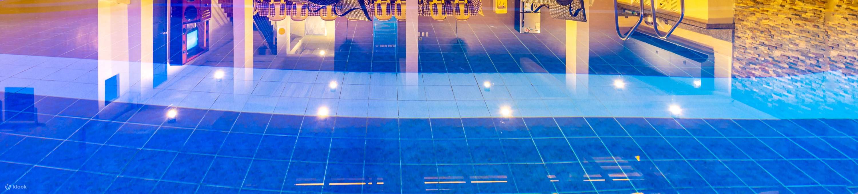 Une piscine avec un toit bleu et des lumières vives tout autour