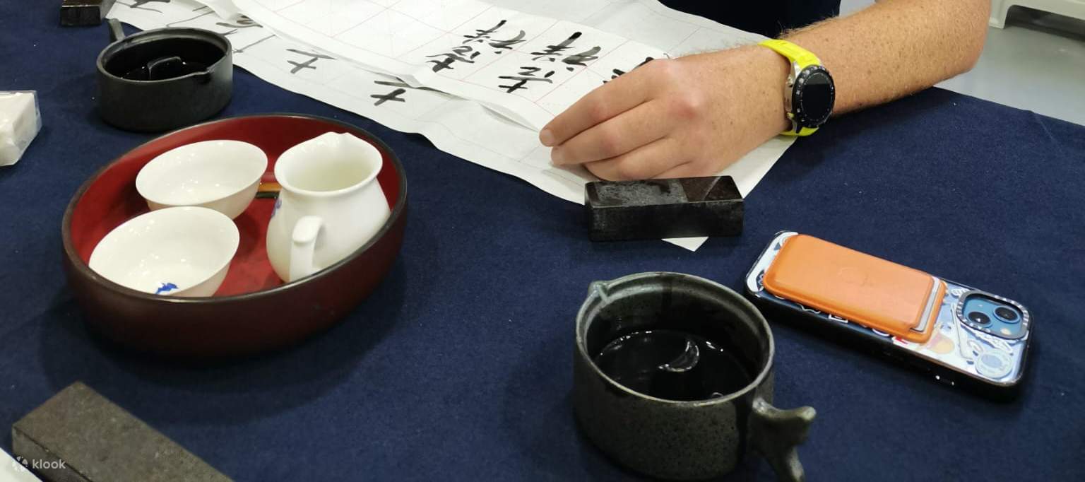 Мужчина пишет китайский иероглиф