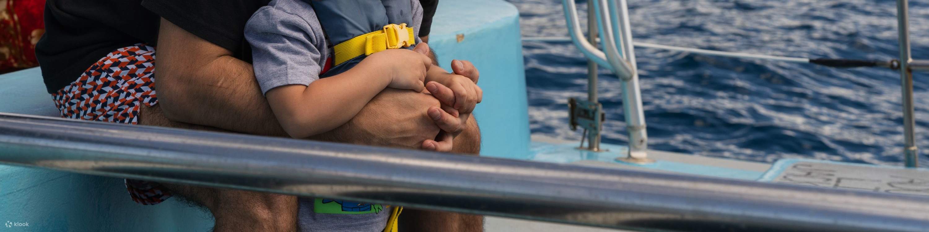 Padre e hijo comparten un momento especial mientras observan ballenas juntos.