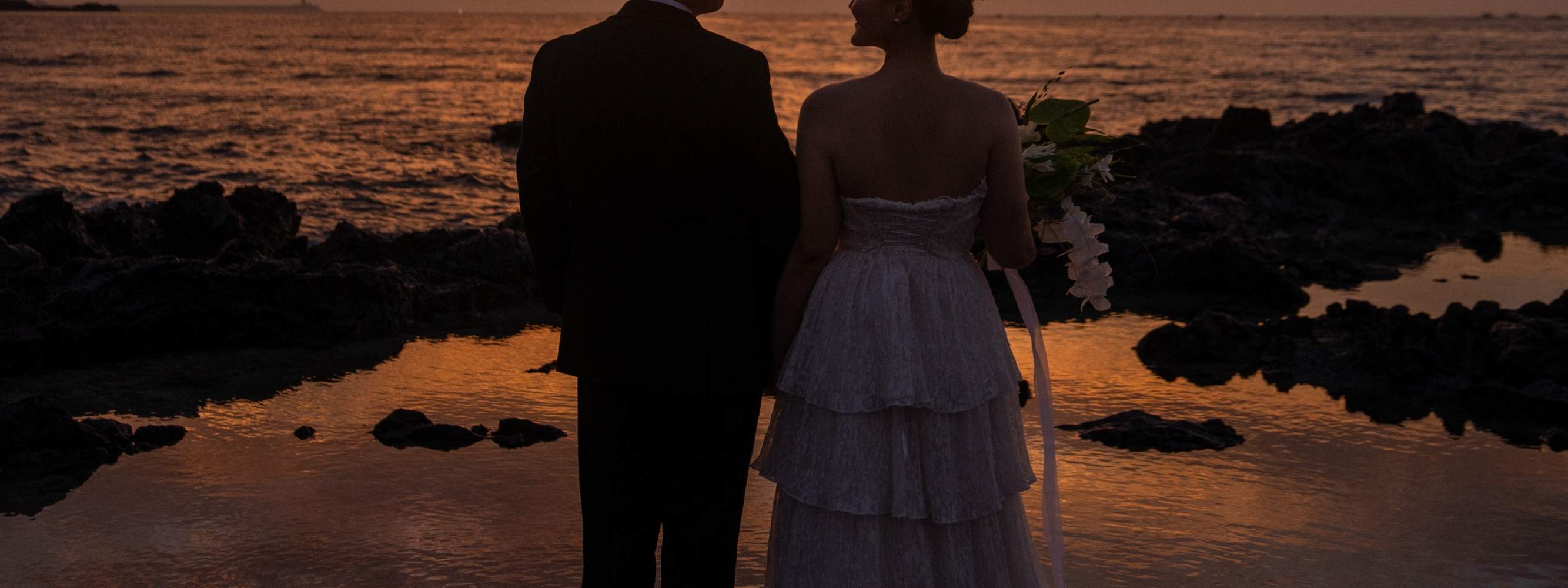 Une séance photo romantique en plein air avec une vue imprenable sur le coucher de soleil de Jeju — parfait pour des souvenirs de pré-mariage.