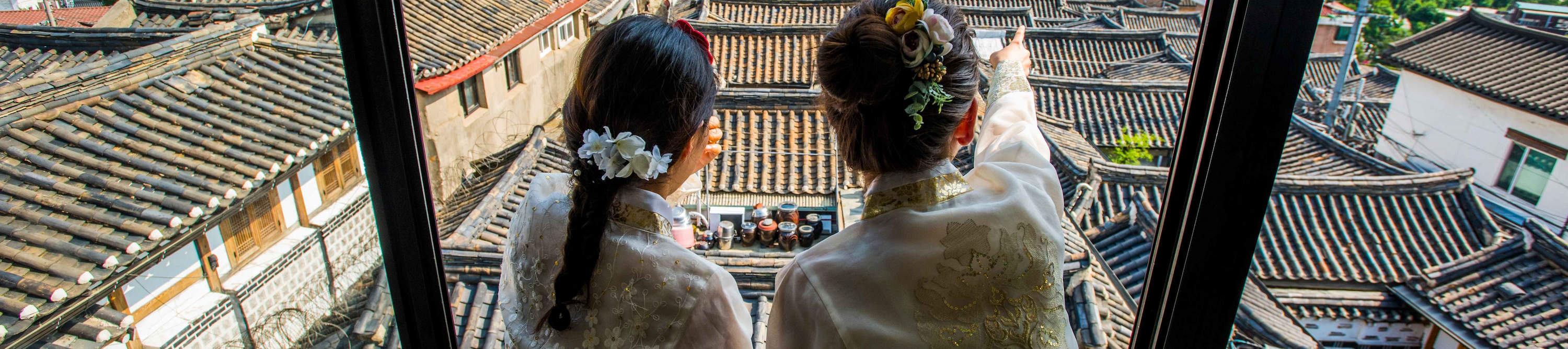 Pemandangan dari Atap Bukchon Hanok Village – tempat pemotretan hanbok terbaik yang menghadap ke atap genteng dan cakrawala Seoul dengan N Seoul Tower.