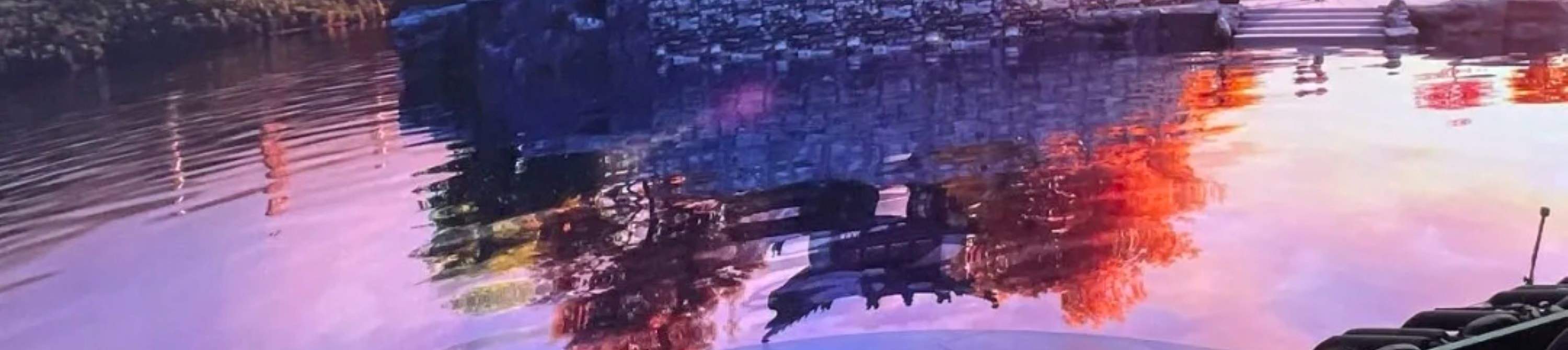 Il padiglione cinese si erge sul lago, con gli alberi colorati dal tramonto che si riflettono sulle antiche torri di montagna in lontananza.