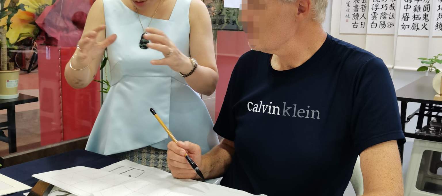 Mann schreibt chinesisches Schriftzeichen