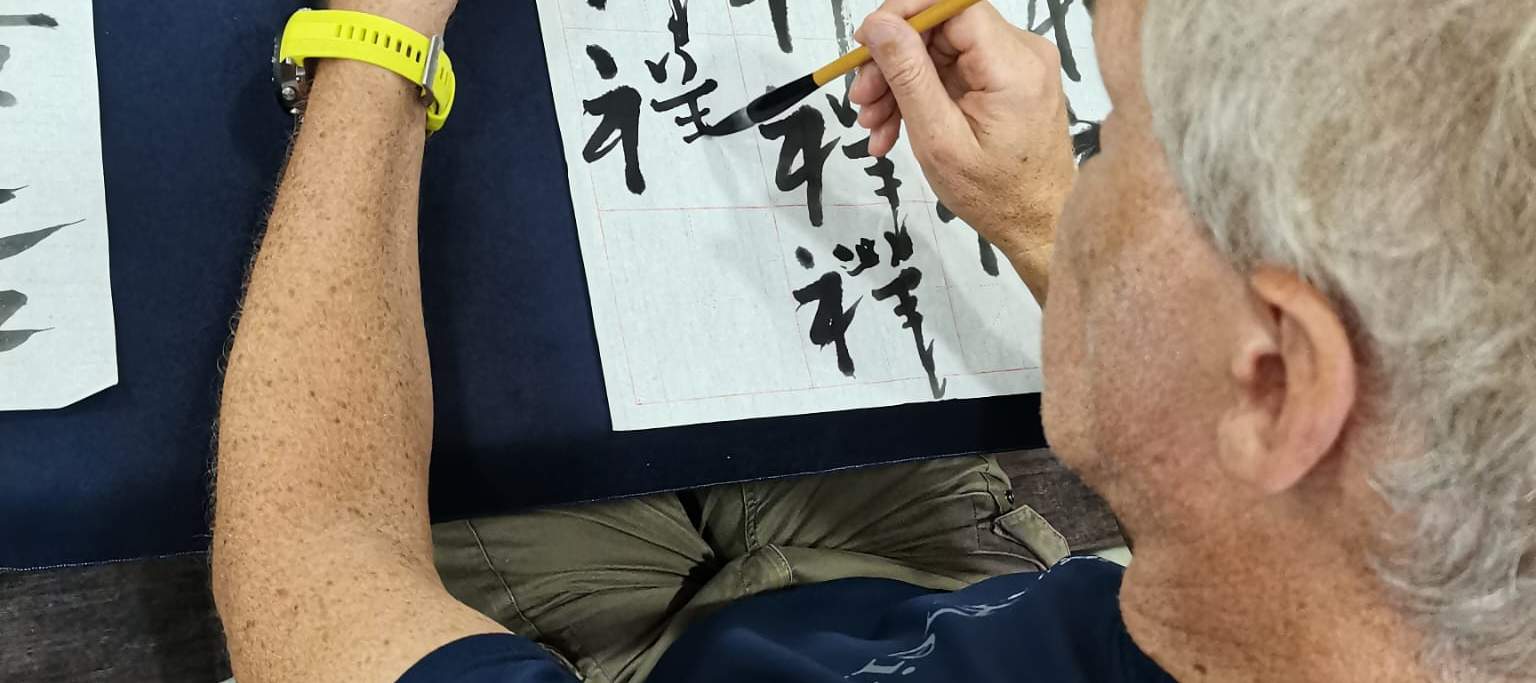 Mann schreibt chinesisches Schriftzeichen