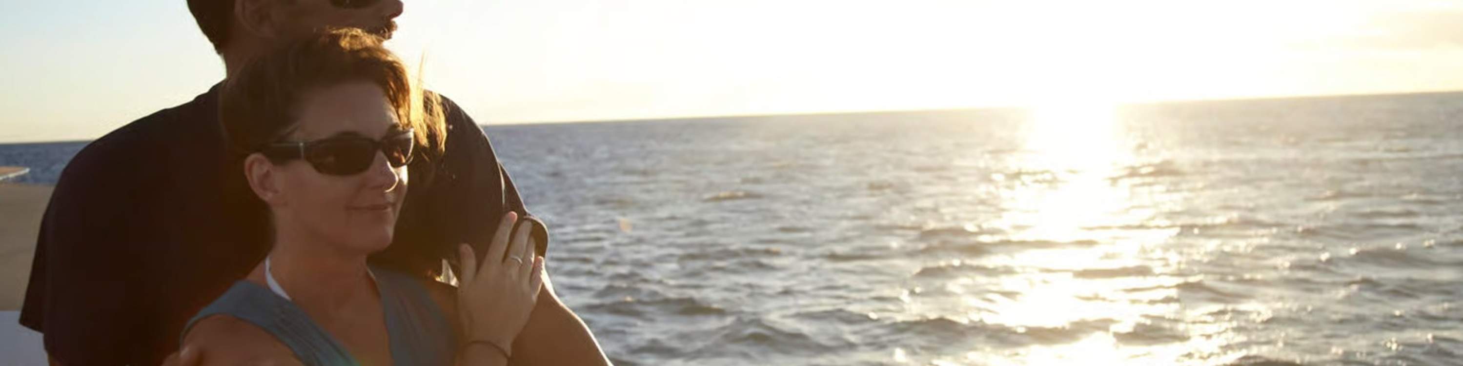 Admire tropical evening glow while a couple shares a quiet sailing moment