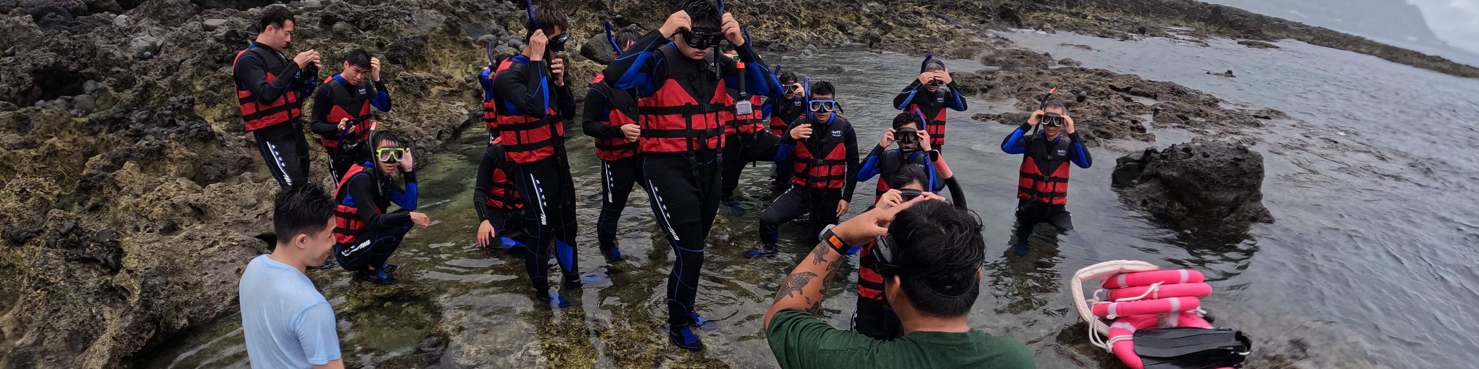 The instructor guides members on how to use diving masks.