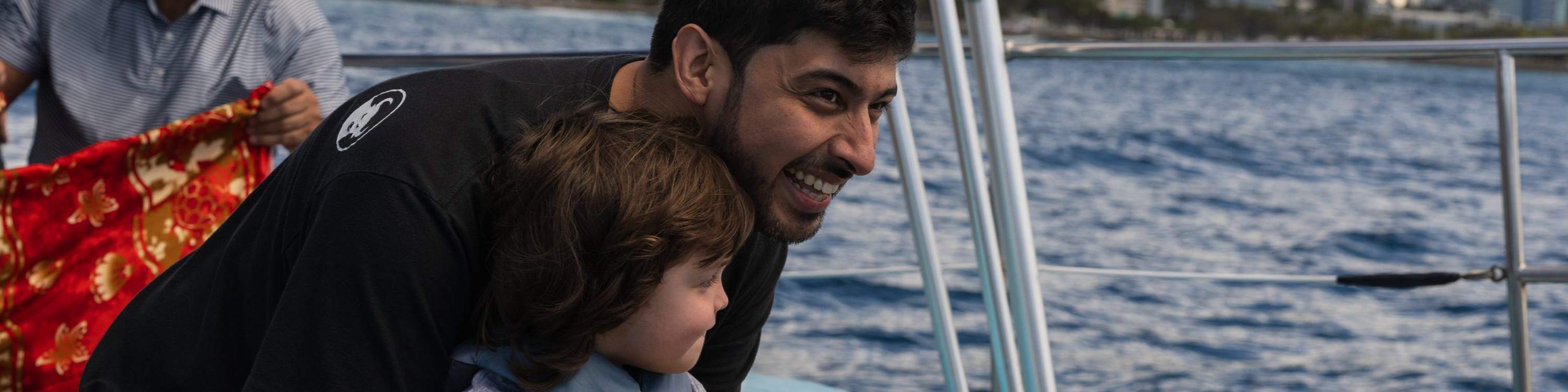 Padre e hijo comparten un momento especial mientras observan ballenas juntos.